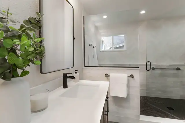Herringbone Hues bathroom remodel in Sammamish with a white quartz vanity, black fixtures and glass-enclosed shower