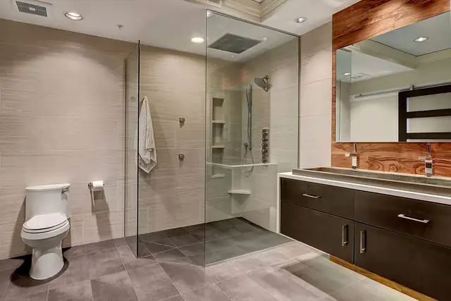 Custom Luxury bathroom remodel in Kirkland with a curbless glass shower, floating dark vanity and wood accent wall